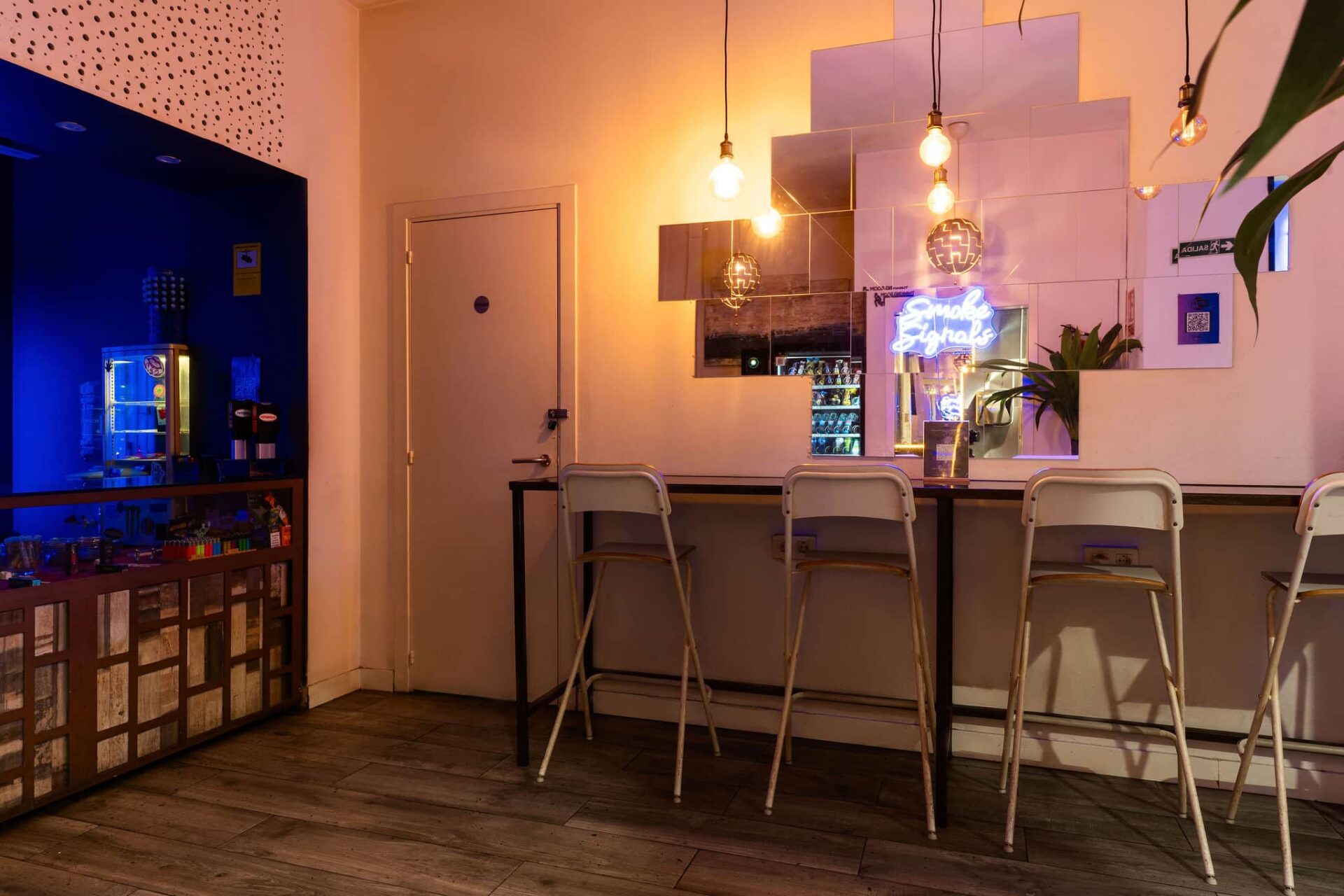 Барная стойка с зеркалами и неоновой вывеской в каннабис-клубе Smoke Signals Барселона